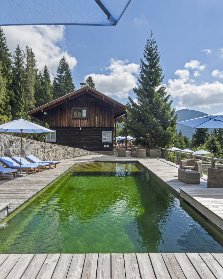Hotelbad „Silberghaus” in Bayrischzell Naturpool mit Balena-System mit Liegen des Hotelbad „Silberghaus” in Bayrischzell, im Hintergrund die Alpen