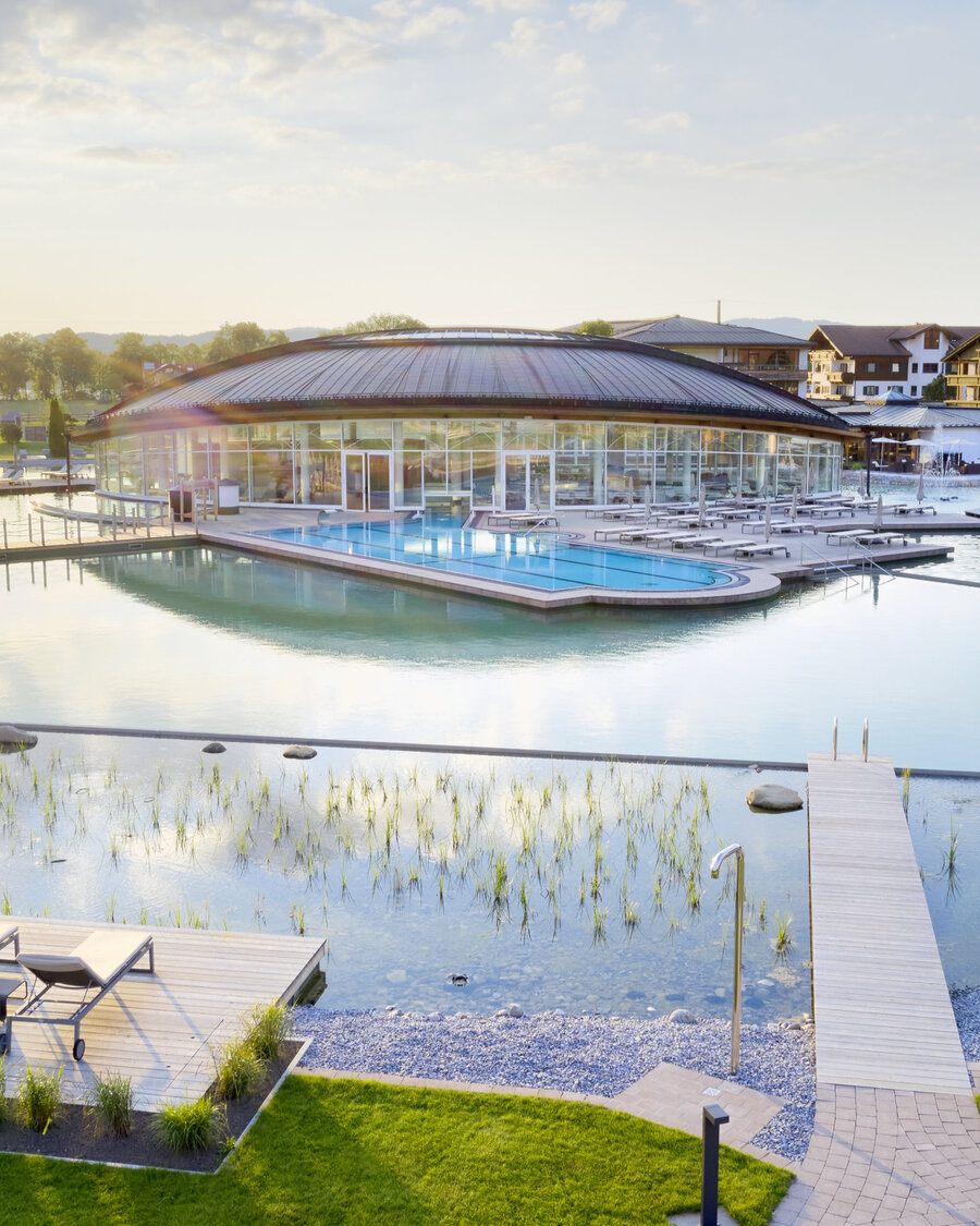 Poollandschaft mit Liegen Die Poollandschaft mit Balena-System des „König Ludwig” Wellness & SPA Resort mit Badeliegen und Bepflanzung